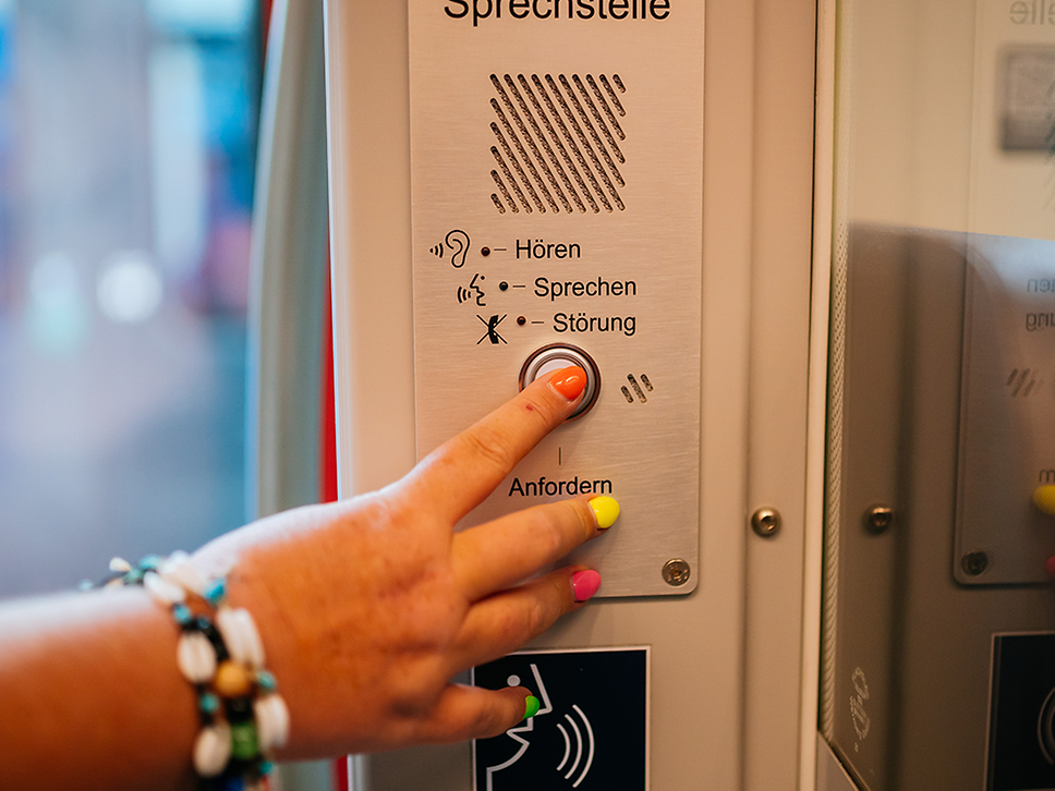Eine Frau drückt den Notrufknopf in einer S-Bahn